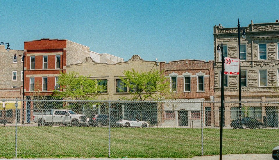 Chicago brick flats behind a fenced empty lot